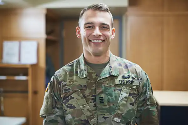 Young soldier in US Army uniform standing in dorms of military academy