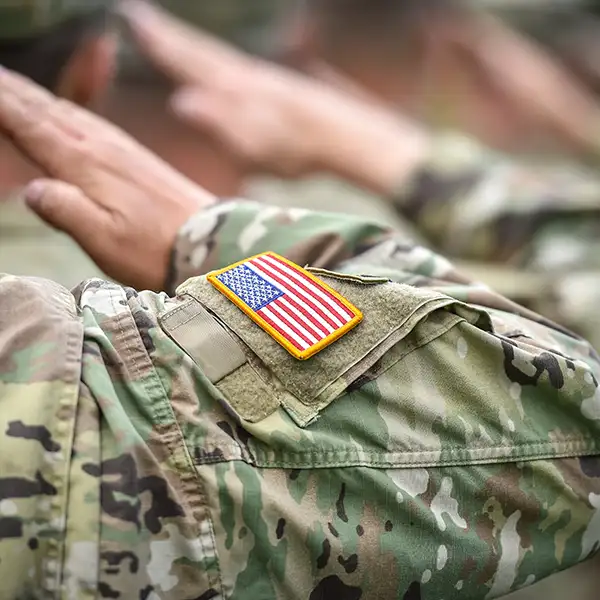 Detail shot with American flag on soldier uniform, giving the honor salute during military ceremony