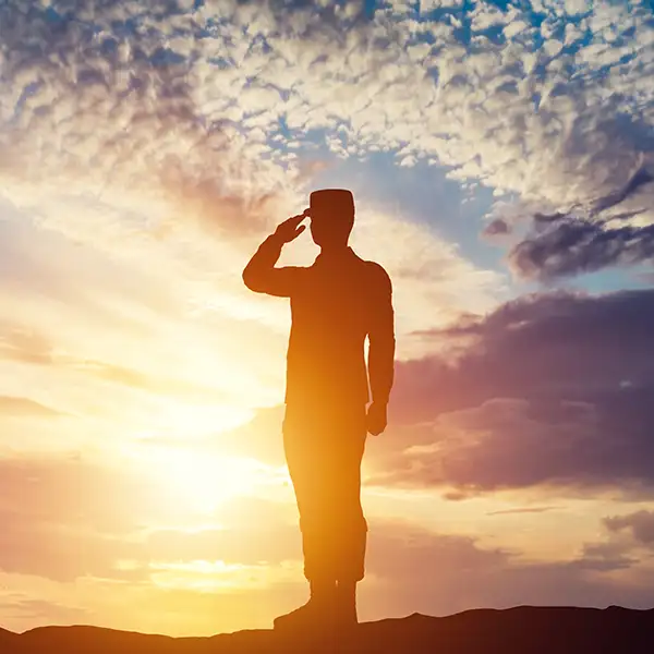 Soldier saluting at sunset