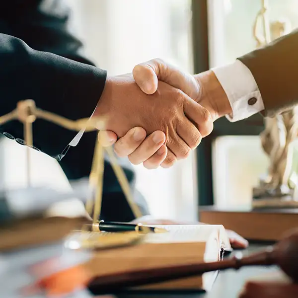 Handshake in office with gavel and scales